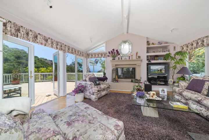 Living room with 3 sets of french doors opening onto the expansive ocean view deck