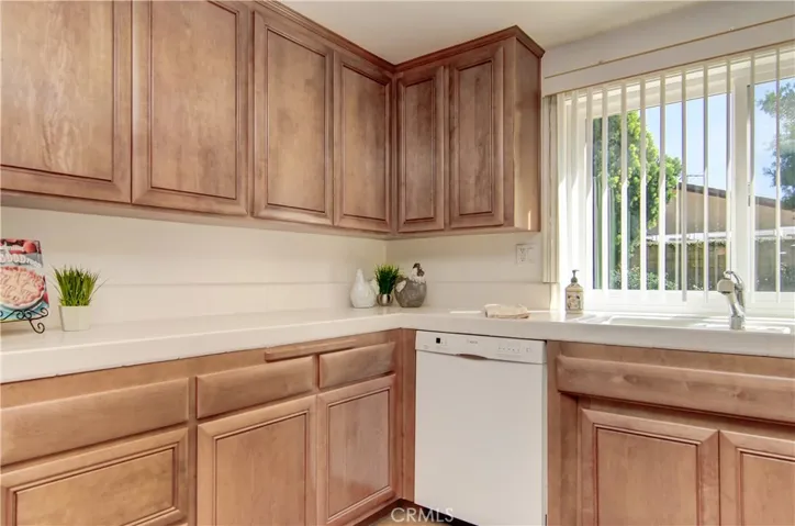 The kitchen boasts tons of cabinetry and gleaming white counters.