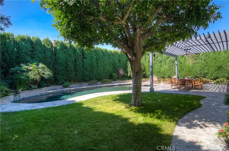 A yard with everything you want...pool, spa, waterfall, stone terrace, arbor, shade tree and GRASS too!