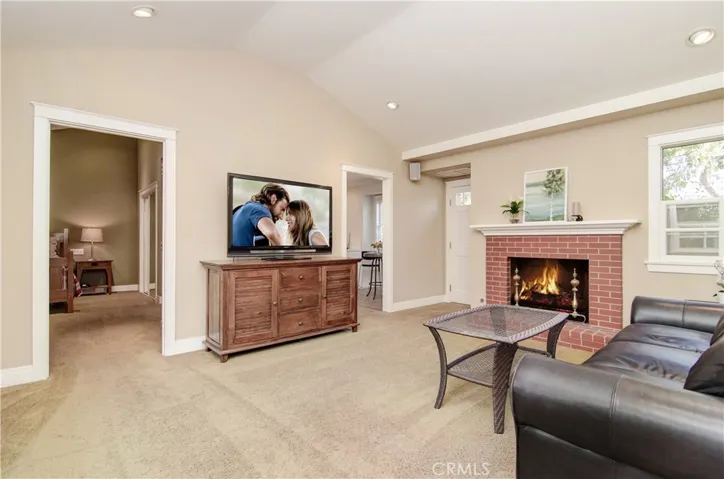 Wow...this living room in the apartment is awesome...vaulted ceilings, fireplace, recessed lighting and more!
