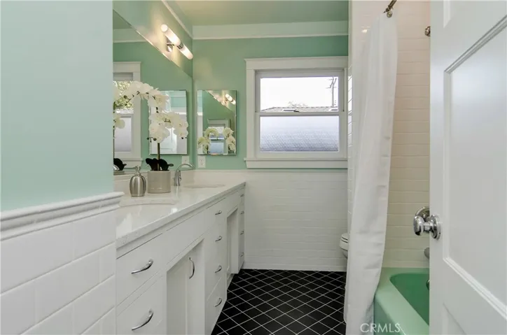 Classic meets contemporary for sure in this stunning hall bath.  New dual sink custom vanity, subway tile accents and cool original bath tub that anchors the style.