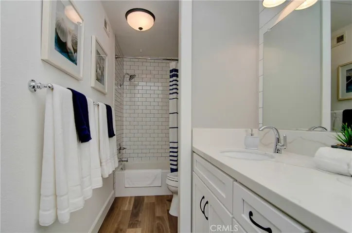 Gorgeous bath has dual sink shaker vanity and ship lap details. Separate bathing area offers soaking tub with classic subway tile surround.