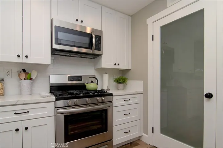 Loads of beautiful cabinet and counter space...even the door to the laundry room adds a designer touch!