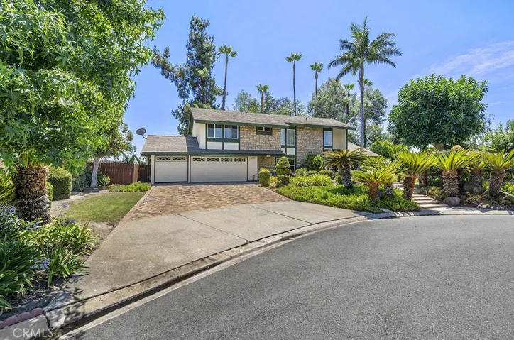 Long driveway with pavers, a 3 car garage, and a huge front yard.