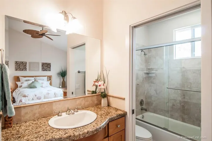 The second bathroom has travertine flooring with a full shower and bath.
