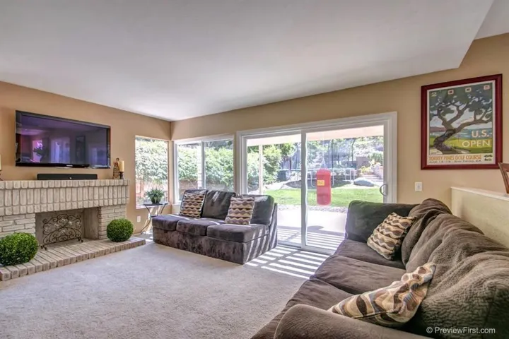 Family Room with Fireplace and Sliding Door to the Patio