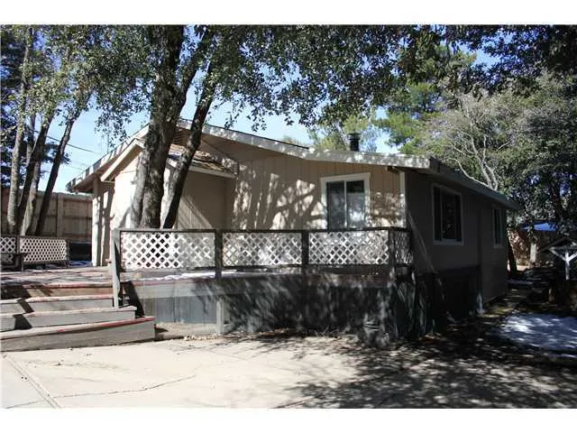 Neat house with large deck and great shade trees.