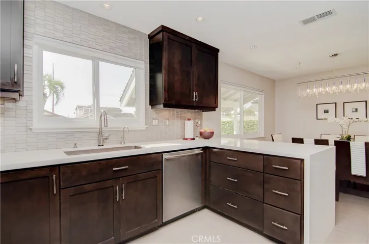 So many nice features here...rich wood cabinetry, quartz counters, gorgeous backspalsh tile details and stainless appliances.