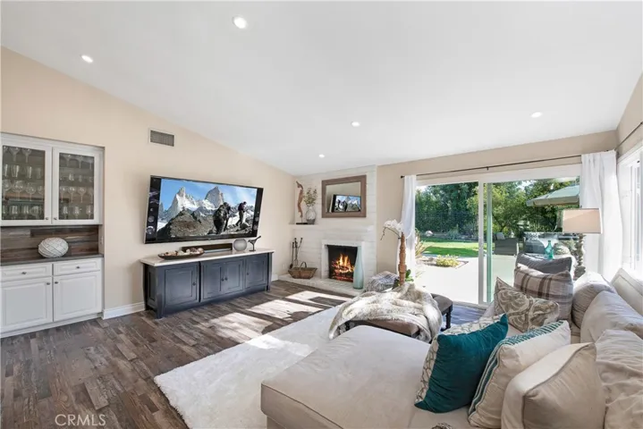 Cozy Family room opening to the outdoor patio. Built-in with reclaim wood accents. Fire Place, vaulted ceiling and a lot of natural light.