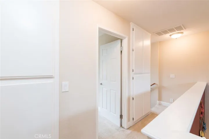 View of hallway between bedrooms 2 and 3.  2 separate storage cabinet areas for linens.