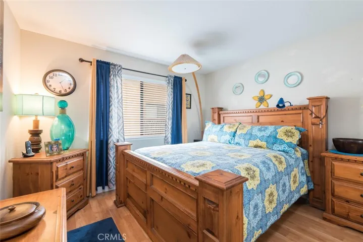 Main floor bedroom with laminate wood flooring, adjacent to hall bathroom.
