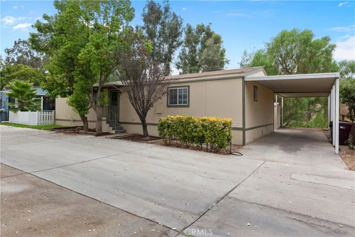 Front of Mobile Home offering parking space as well.