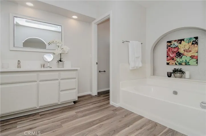 Large master bath has vanity with storage, large dressing area and big soaking tub.