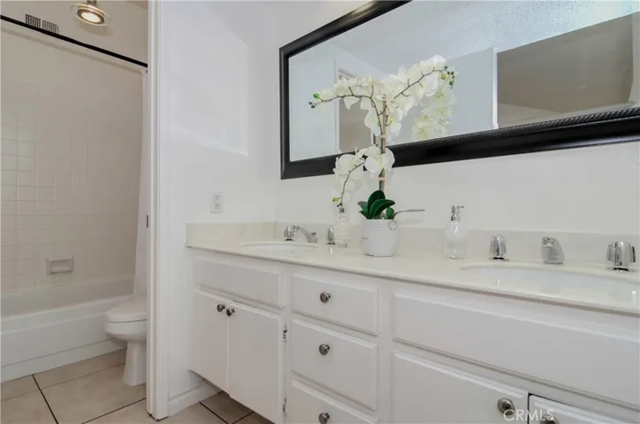 Dual vanity master bath with soaking tub, tile flooring, an white-tiled shower!