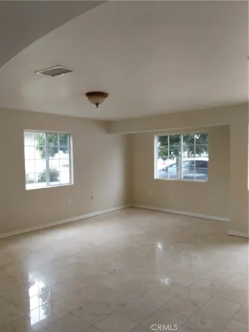Sun filled LIVING ROOM is huge, and easycare tile flooring keeps upkeep a breeze!