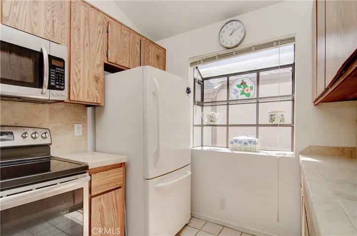 Sunny kitchen has garden window and plenty of cabinet and counter space for any cook.
