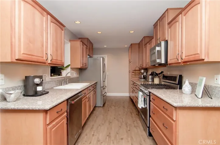 Loads of rich wood cabinetry and granite counter space offer plenty of room for more than one cook in the kitchen. Large drawers for pots and pans and tall pantry allow storage galore.