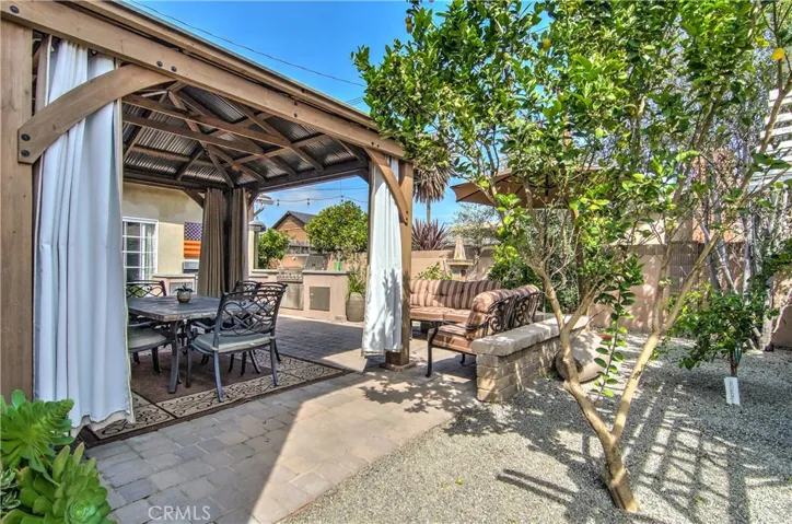 Easy care rear yard has nice paver areas, citrus and fruit trees, and multiple outdoor "rooms."