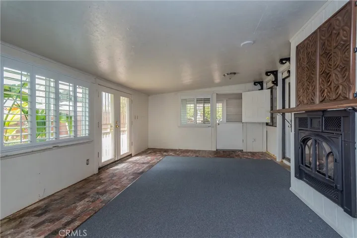 Enclosed patio is now a great flex space with new carpet bordered by brick
