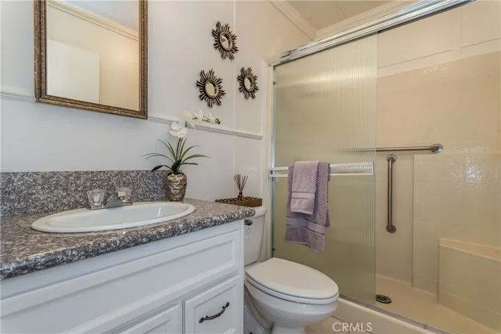 Full bathroom off the hallway with grab bars and a seat in the shower