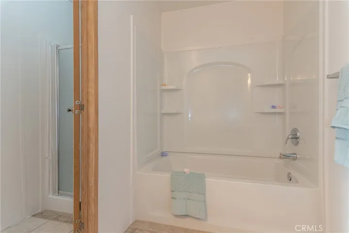 Master bathroom with a tub and shower stall