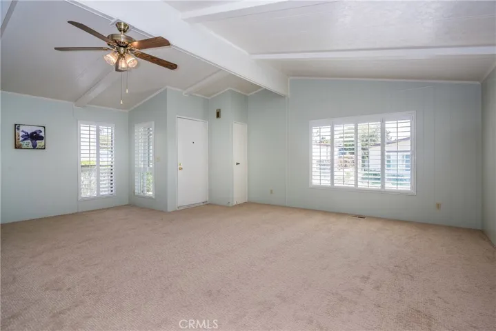 Light and bright living area with new carpet, fresh paint, and vinyl plantation shutters