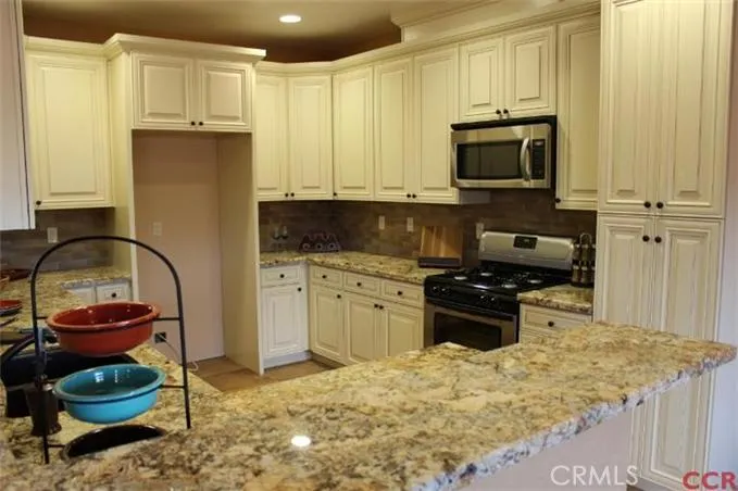 Kitchen with ivory glazed maple cabinets and granite countertops.