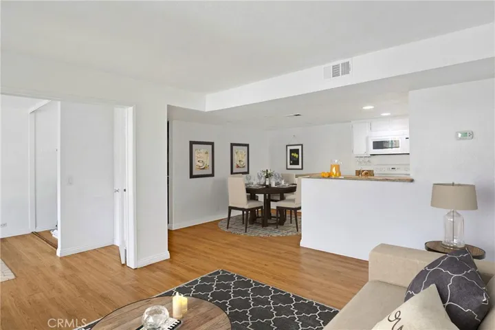 Living room with view toward dining area, virtually staged.