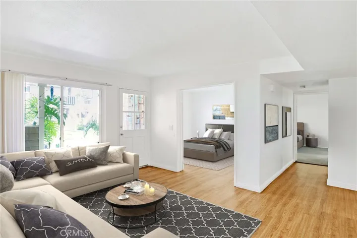 Virtually staged living room with view to third bedroom