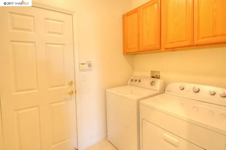 Indoor laundry with extra cabinets.