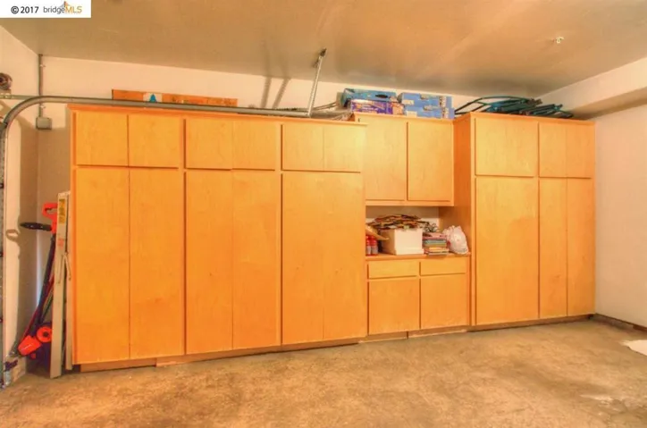 Spacious 2 car garage with extra cabinets installed along one wall.
