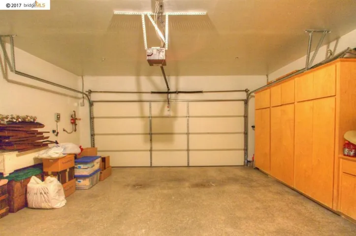 Spacious 2 car garage with extra cabinets installed along one wall.