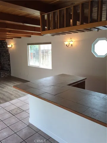 Den: Built-in bar with tile counters, overhead glassware/bottle shelving.