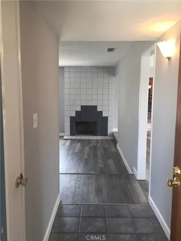 View from Tiled Foyer w/Coat Closet into the Formal Living Room w/Fireplace.