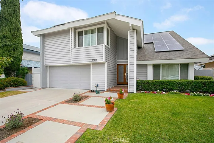 View of front - new vinyl siding, garage door, and solar panels.