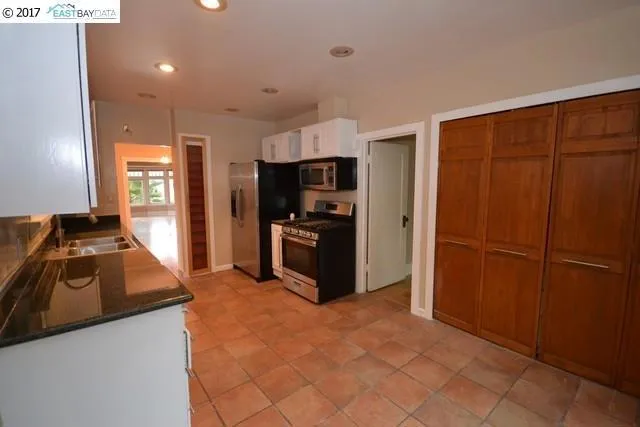 Kitchen with stainless steel appliances, granite counters and breakfast area.