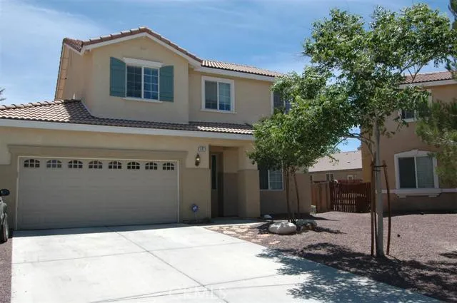 Front view showing tiled roof, metal sectional windowed garage door and low maintenance landscaping. Note that the garage will accommodate THREE vehicles.