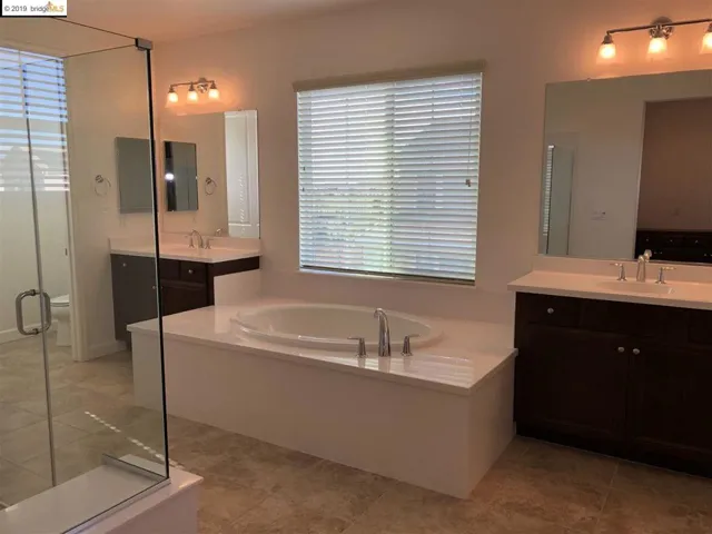 His and hers sink separated by a nice tub.