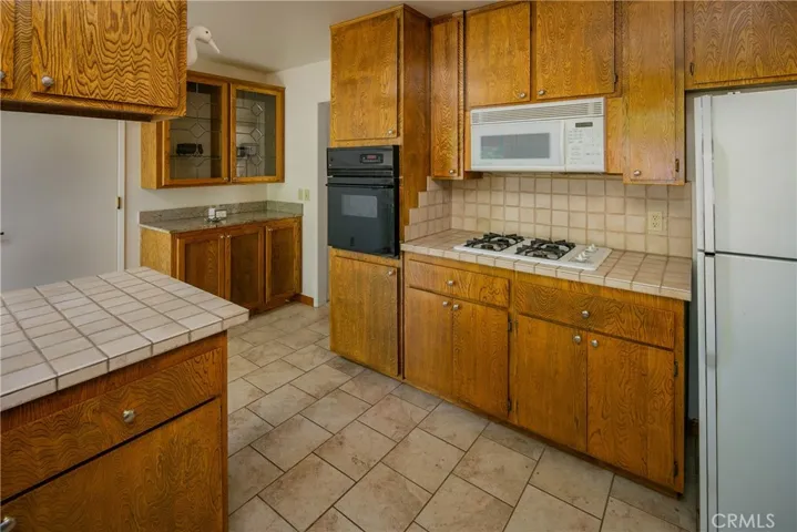 Display your treasures in the cabinet with glass doors.  The kitchen features an electric oven, gas cook top, microwave and refrigerator - all included.