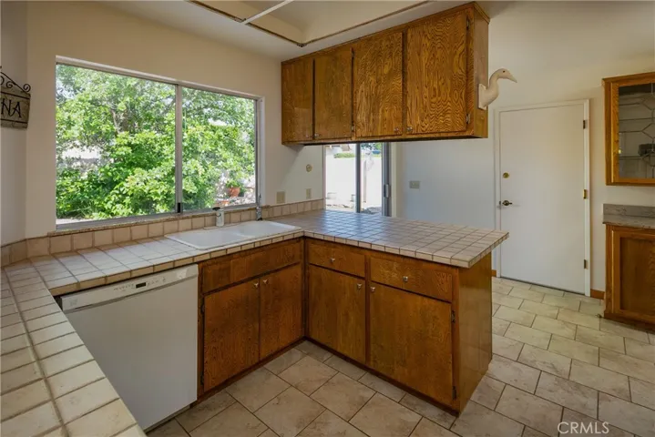 Tile flooring and counter tops accent the kitchen. The door to the garage provides handy access for unloading the groceries.