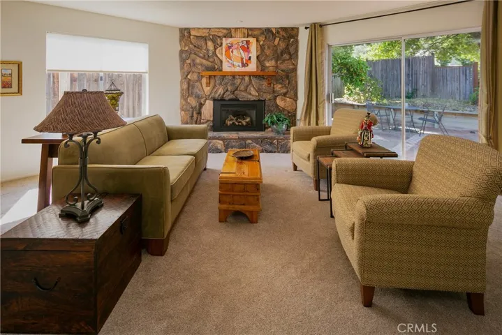 The living room features a rock fireplace focal point and a slider to the backyard.
