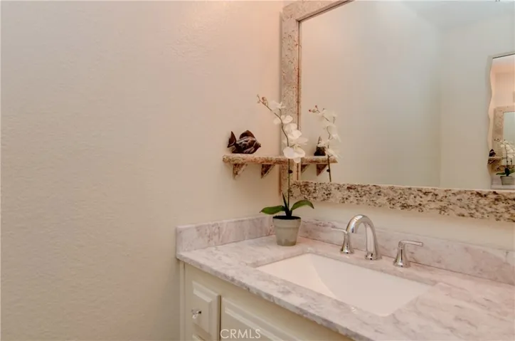 Main level powder room has stone counters and updated fixtures.