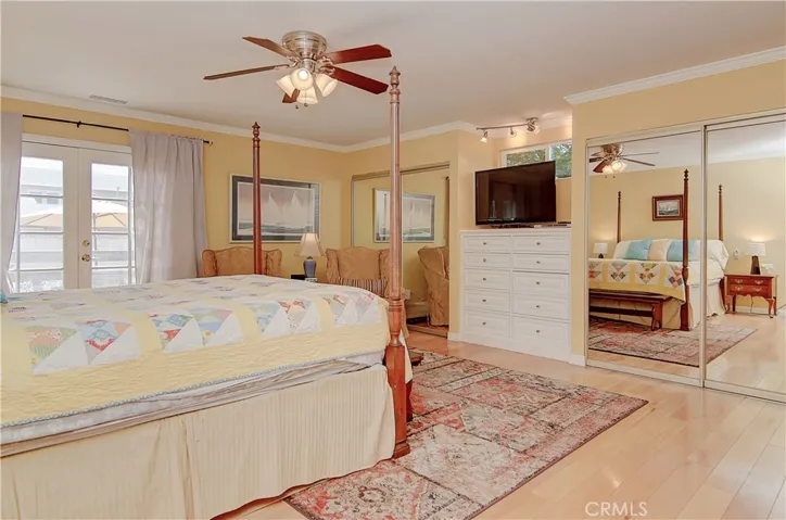 Wood flooring, crown molding, ceiling fan, access to the backyard, his and hers closets... what else does a master suite need?