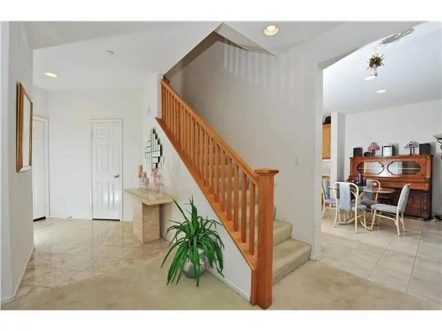 Classy entry framed by wood spindle staircase