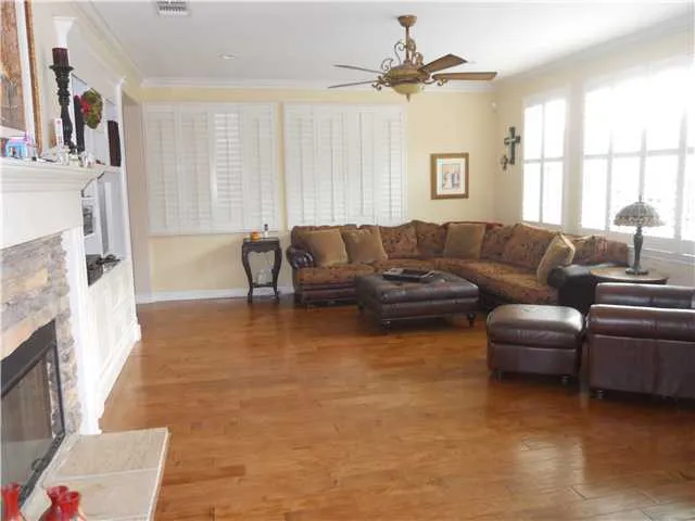 Family room with hardwood flooring, fireplace & wood shutters