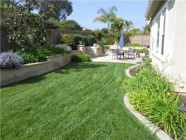 Inviting backyard has grass and hardscape