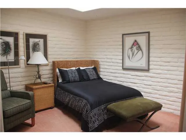 This second guest bedroom offers a skylight above with ceiling fan and built-n wall unit.