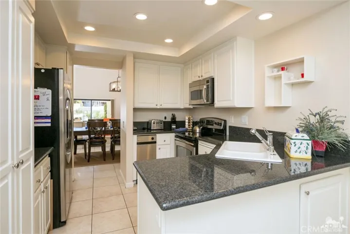 The sleek kitchen features granite counters...