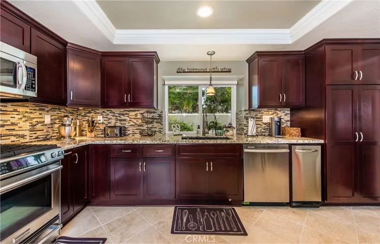 Beautiful tumbled travertine floors, granite countertops, pantry with pull out drawers, custom soft close cabinetry, recessed lighting and so much more!