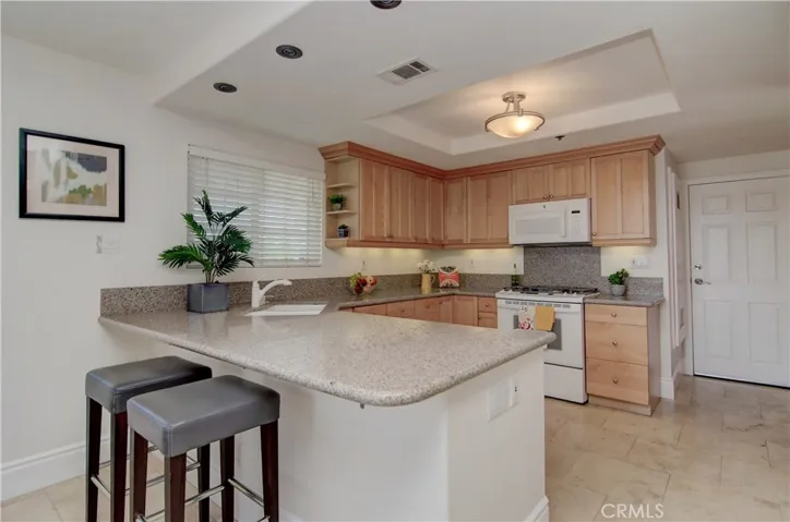 This fantastic kitchen has it all...loads of cabinet and prep space, quartz counters plus breakfast bar is the perfect place to hang out with the cook or for kid's homework.